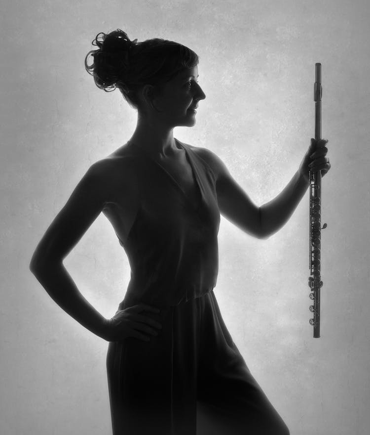 Grayscale silhouette of Fiona holding her flute